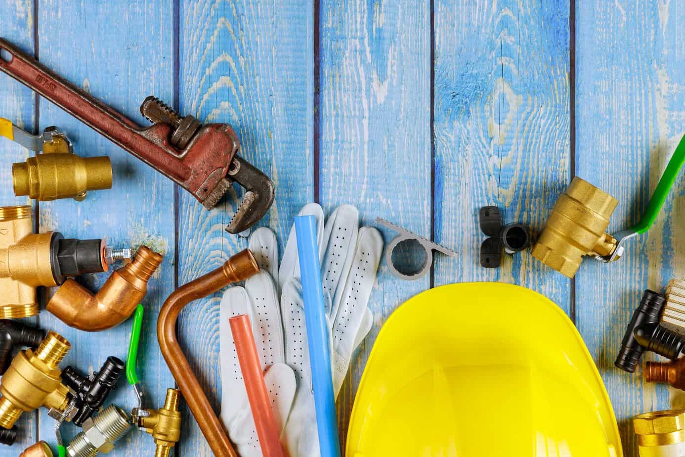 Plumbing pipes fittings on valves wrench work gloves in the water supply
